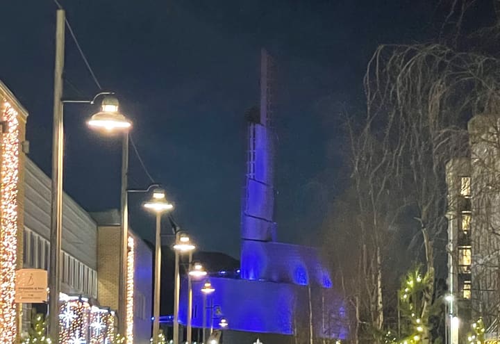 The Northern Lights Cathedral in Alta lit blue on a snowy winter evening