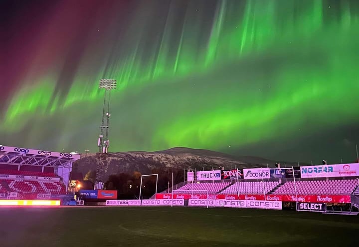 Green aurora above a Nordic football stadium