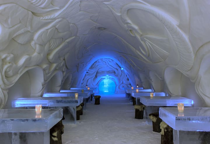 Ice tables and carved snow walls inside the SnowCastle restaurant in Kemi