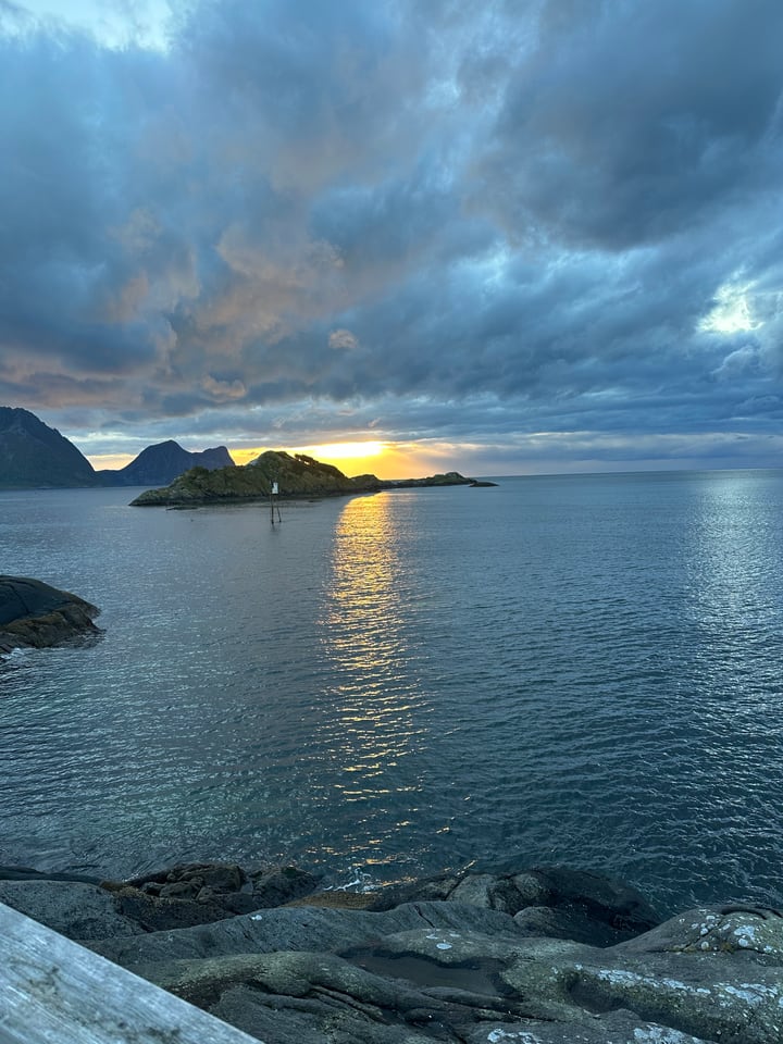 Sunset over a rocky Norwegian coast and calm water